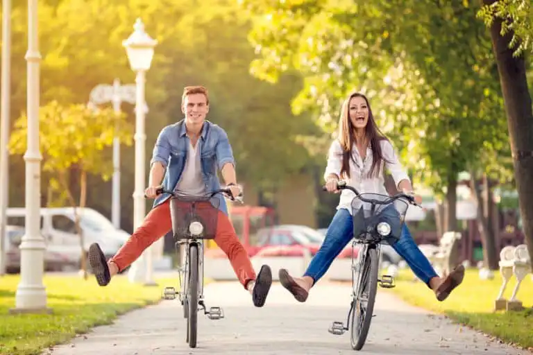 Happy couple riding bikes around stoney brook villas neighborhood